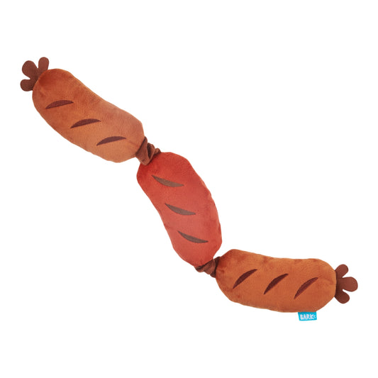 Plush dog toy shaped like sausages on a white background