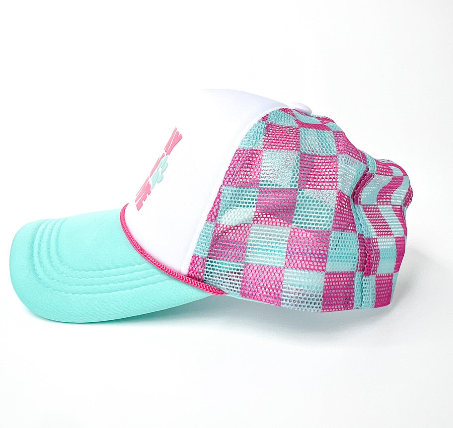 A trucker-style cap with a white front panel, pink and mint green checkered mesh back, and a solid mint green brim, shown on a white background.