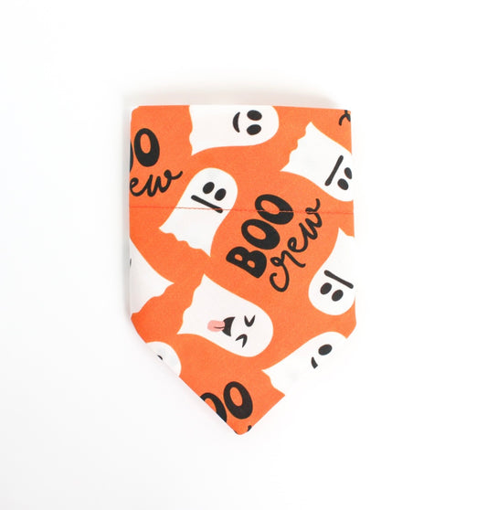 An orange pet bandana with a white and black 'Boo Crew' Halloween ghost pattern, displayed flat against a white background.