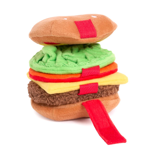 Toy hamburger with layers of bread, lettuce, tomato, and cheese on a white background